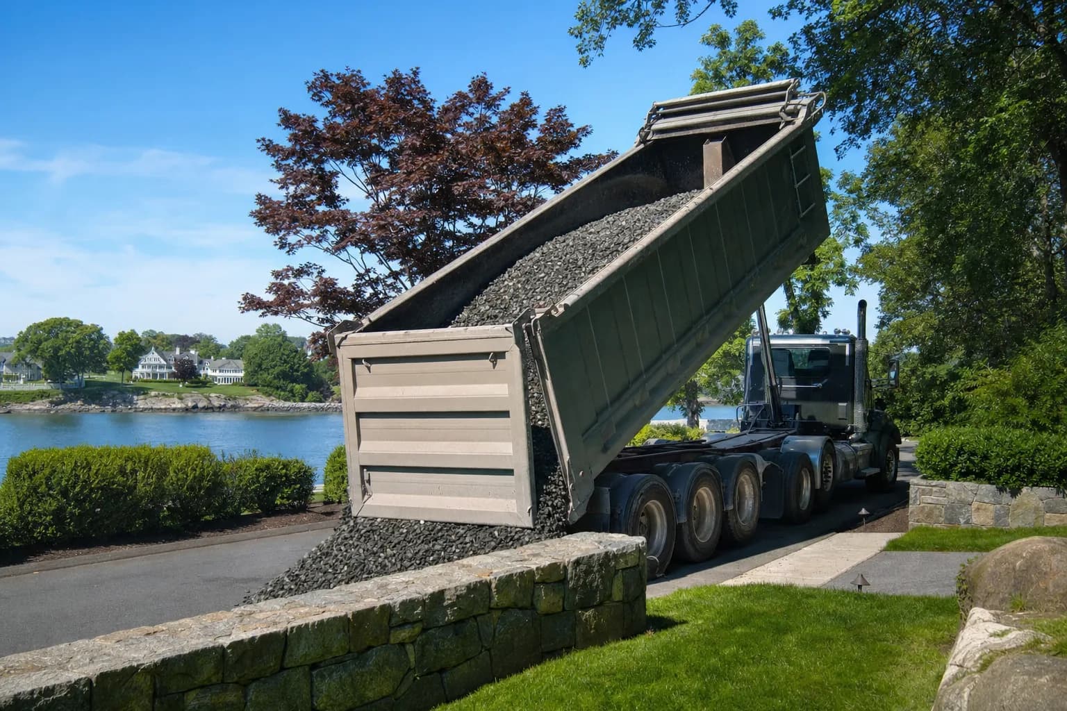 Dump truck delivering gravel to a residential property